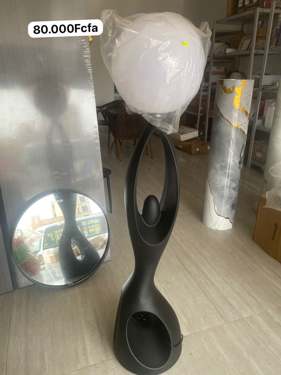 Lampadaire statue noire portant un globe lumineux